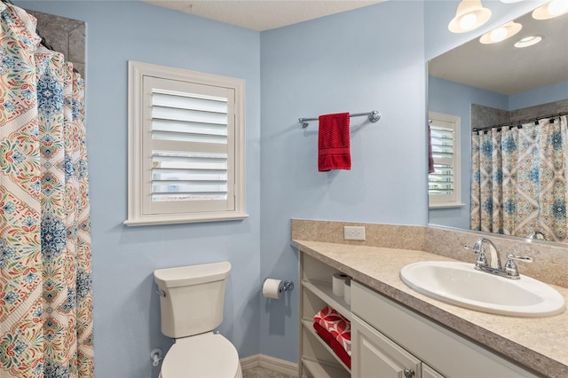 bathroom featuring curtained shower, vanity, and toilet