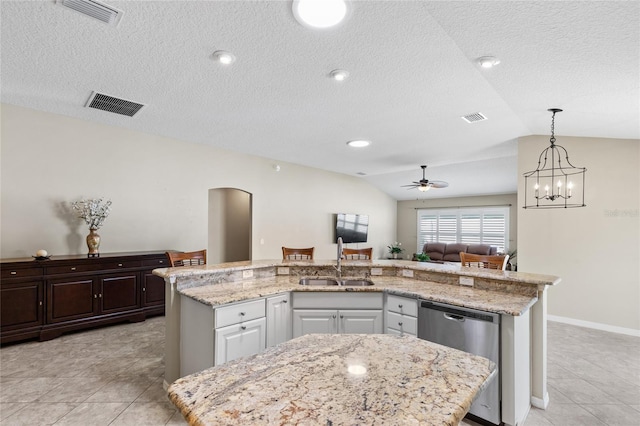 kitchen featuring white cabinets, vaulted ceiling, and a center island with sink