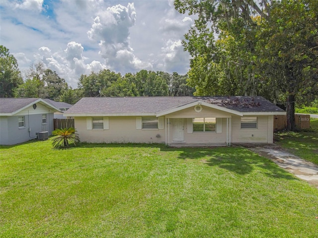 ranch-style house with central air condition unit and a front yard