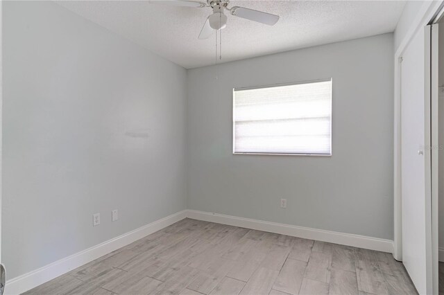 unfurnished bedroom featuring light wood-type flooring, a textured ceiling, and ceiling fan