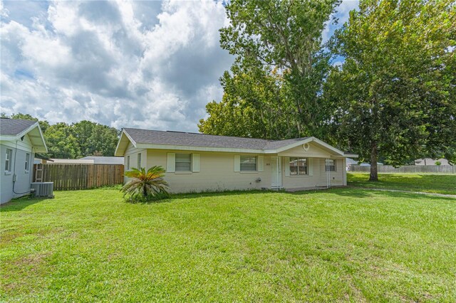 rear view of property with a yard and central AC