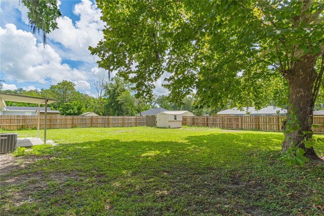 view of yard featuring a shed and central AC unit