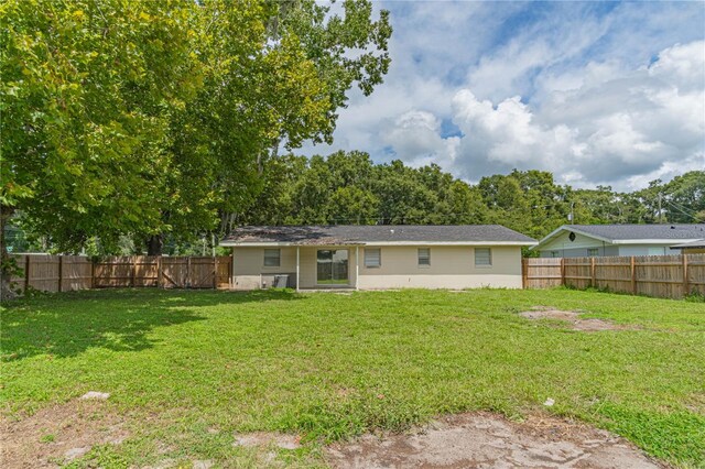 rear view of property featuring a lawn