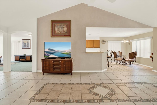 living area with light tile patterned floors, baseboards, and arched walkways