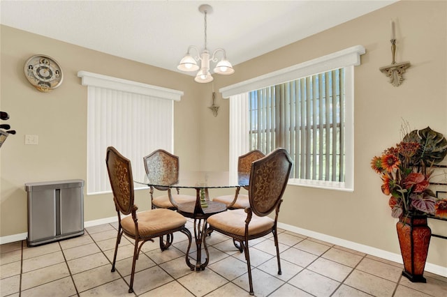 dining room featuring light tile patterned floors, baseboards, and a notable chandelier