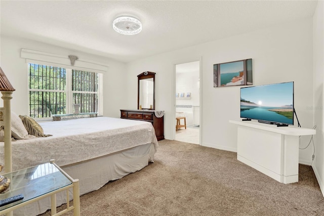 bedroom with carpet flooring, connected bathroom, and baseboards