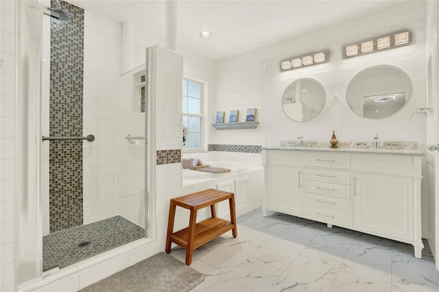 full bath featuring double vanity, a stall shower, a sink, a garden tub, and marble finish floor