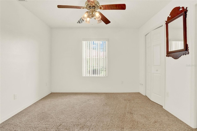 carpeted empty room featuring a ceiling fan