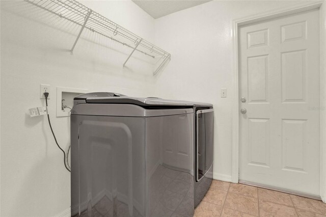 washroom featuring baseboards, independent washer and dryer, and laundry area