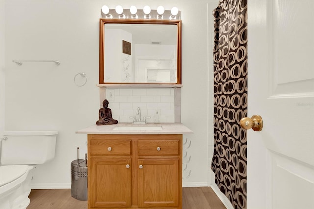 full bath with curtained shower, toilet, decorative backsplash, wood finished floors, and vanity