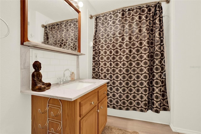 bathroom with a shower with curtain, tasteful backsplash, wood finished floors, and vanity