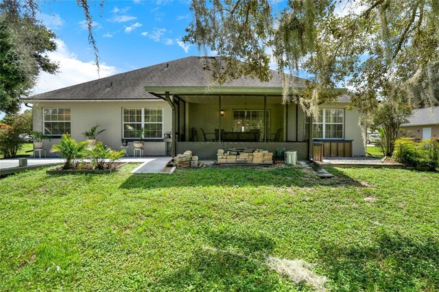 rear view of property with a lawn and stucco siding