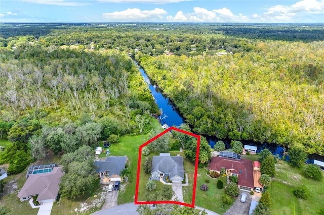 drone / aerial view featuring a view of trees and a water view