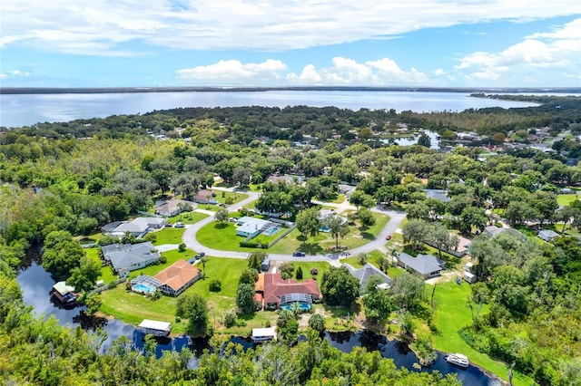 birds eye view of property featuring a forest view and a water view