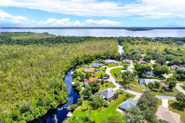 drone / aerial view featuring a residential view, a water view, and a wooded view