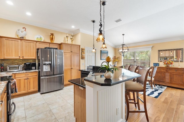 kitchen with hanging light fixtures, a center island, appliances with stainless steel finishes, sink, and lofted ceiling