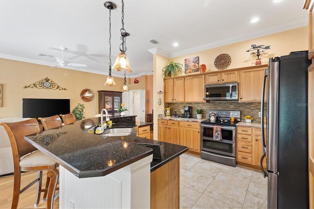 kitchen featuring a center island with sink, stainless steel appliances, sink, and ceiling fan