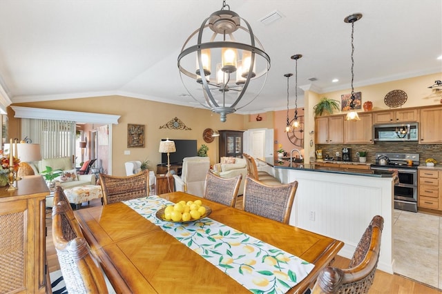 dining area featuring vaulted ceiling, light hardwood / wood-style floors, a notable chandelier, sink, and ornamental molding