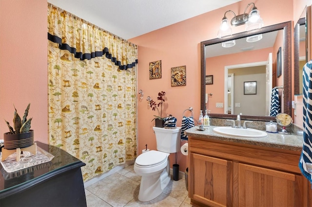 bathroom with tile patterned flooring, vanity, toilet, and walk in shower