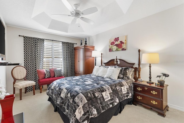 bedroom featuring a tray ceiling, ceiling fan, light carpet, and a textured ceiling