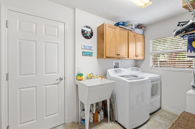 laundry room featuring light tile patterned floors, a textured ceiling, cabinets, and washing machine and dryer