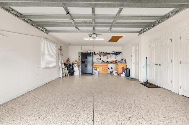 garage featuring black refrigerator with ice dispenser