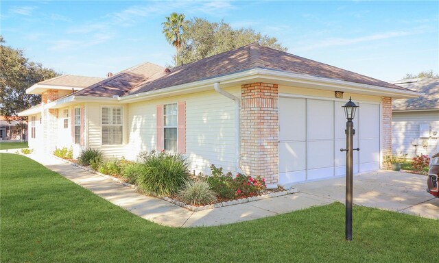 view of side of property with a yard and a garage