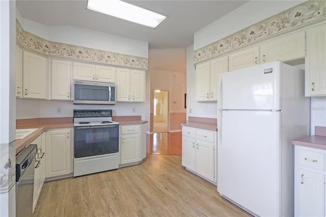 kitchen with light wood-type flooring, a sink, stainless steel appliances, white cabinets, and light countertops