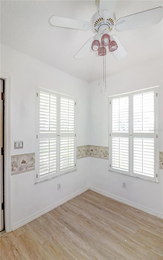 spare room with a textured ceiling and light wood-type flooring