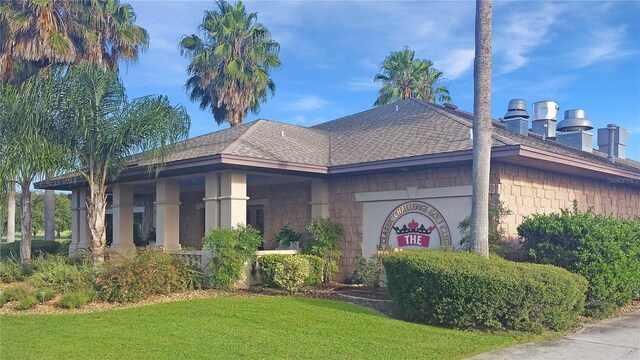 view of front of property with roof with shingles and a front yard