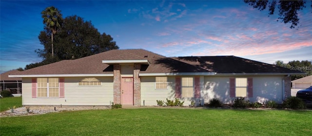 ranch-style home with a lawn