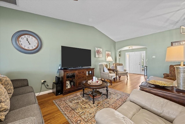 living room with vaulted ceiling and wood-type flooring