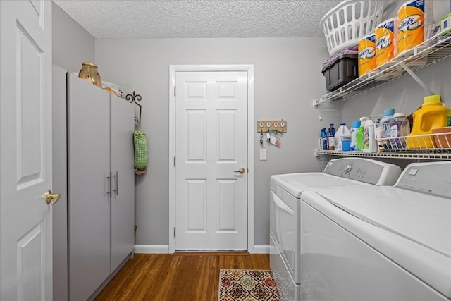 laundry area with dark hardwood / wood-style floors, washing machine and clothes dryer, and a textured ceiling