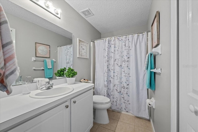 bathroom with vanity, toilet, tile patterned floors, and a textured ceiling