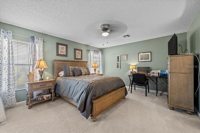 carpeted bedroom with ceiling fan and a textured ceiling