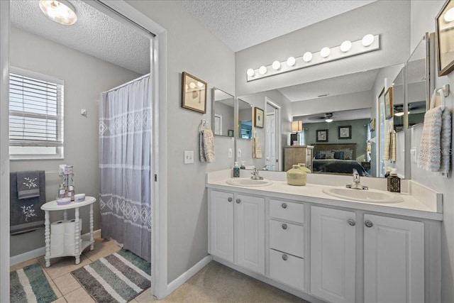 bathroom featuring tile patterned flooring, ceiling fan, a textured ceiling, and vanity