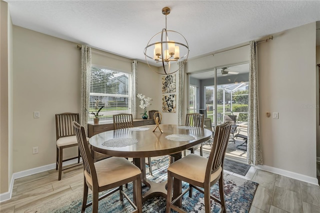 dining area with a textured ceiling and a notable chandelier