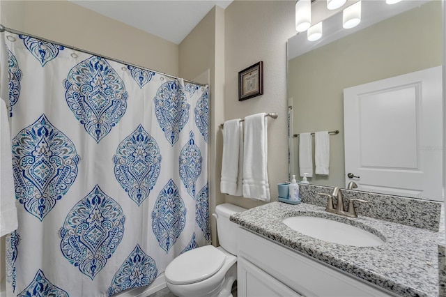 bathroom with curtained shower, toilet, and vanity