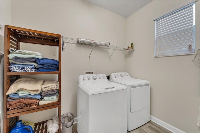 clothes washing area with light wood-type flooring and washing machine and clothes dryer