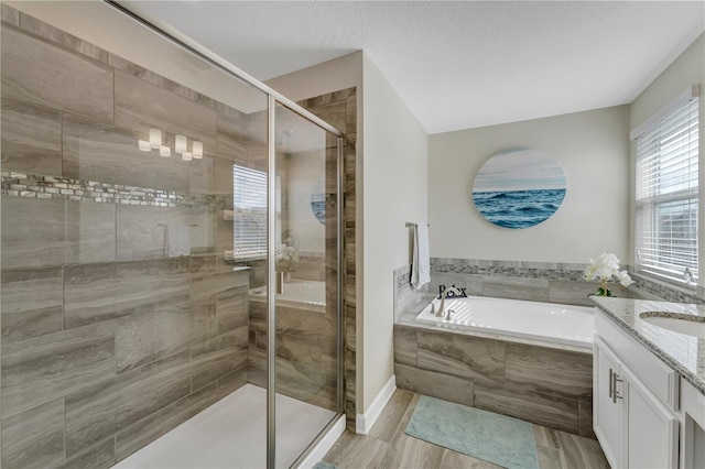 bathroom with a wealth of natural light, vanity, separate shower and tub, and wood-type flooring