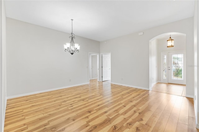 unfurnished room with light hardwood / wood-style flooring and an inviting chandelier