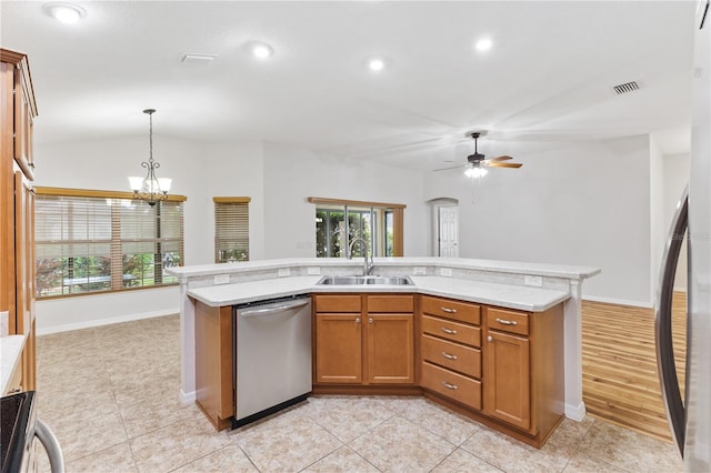 kitchen with pendant lighting, ceiling fan with notable chandelier, dishwasher, sink, and lofted ceiling