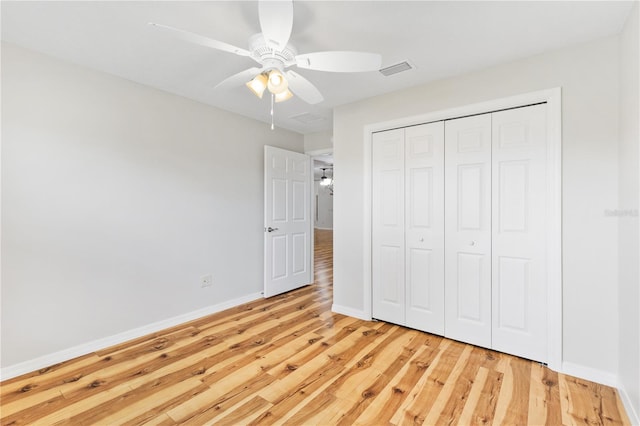 unfurnished bedroom with light hardwood / wood-style flooring, ceiling fan, and a closet