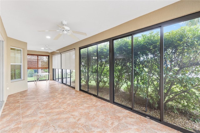 unfurnished sunroom with ceiling fan