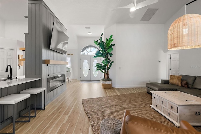 living room featuring sink, french doors, and light hardwood / wood-style floors