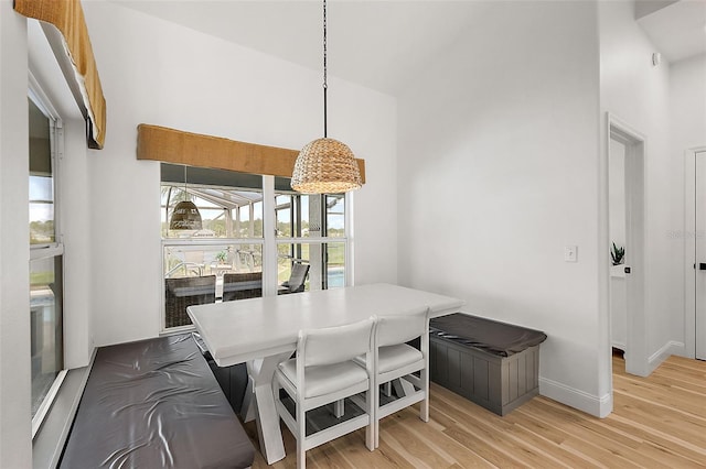 dining space with light hardwood / wood-style floors and vaulted ceiling