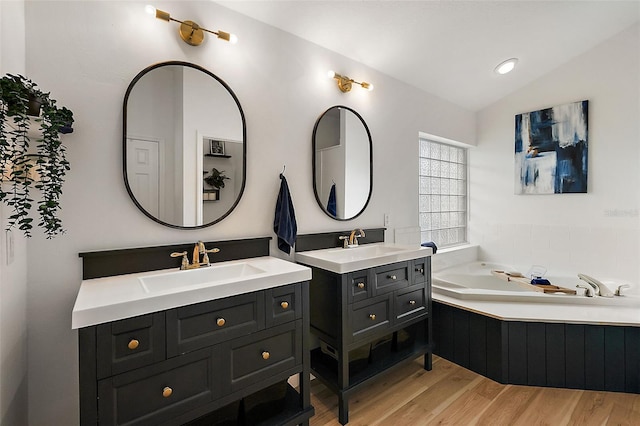 bathroom featuring vanity, a washtub, lofted ceiling, and hardwood / wood-style flooring