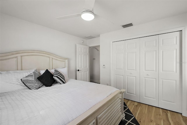 bedroom with light hardwood / wood-style floors, ceiling fan, and a closet