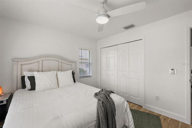 bedroom with light hardwood / wood-style floors, ceiling fan, and a closet