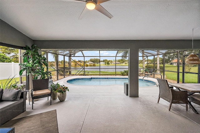 view of pool with a lanai, ceiling fan, a patio, and a yard